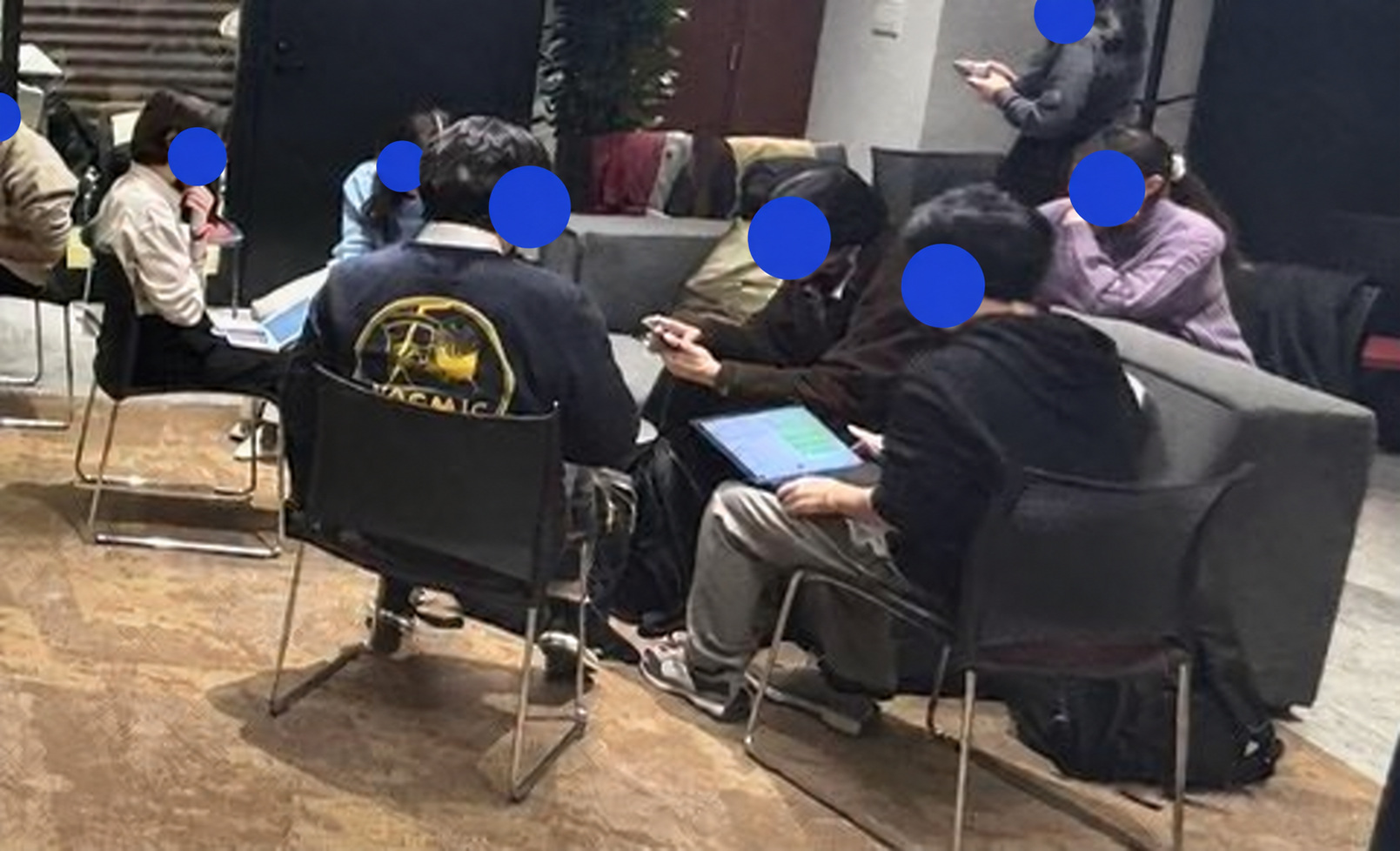 A small group working together during the workshop; faces covered with blue circles.